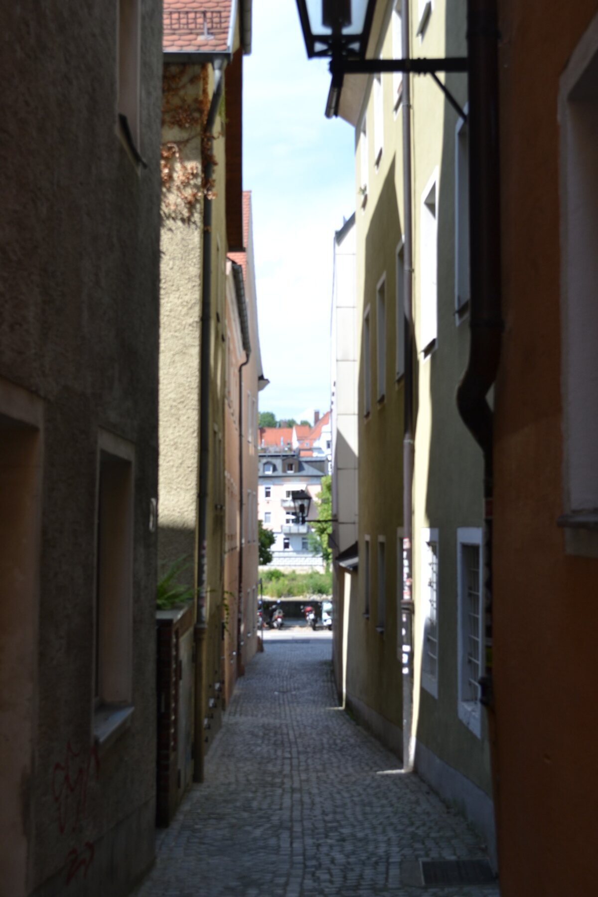 A narrow passage between colorful buildings in Regensburg