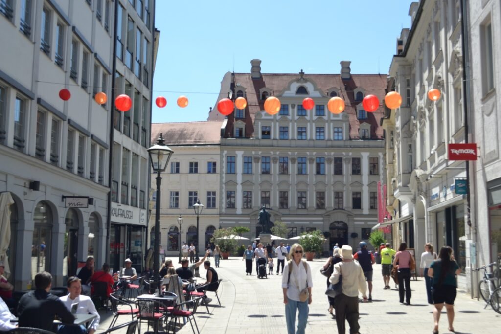 Orange and red lanterns above a lively street in Augsburg.